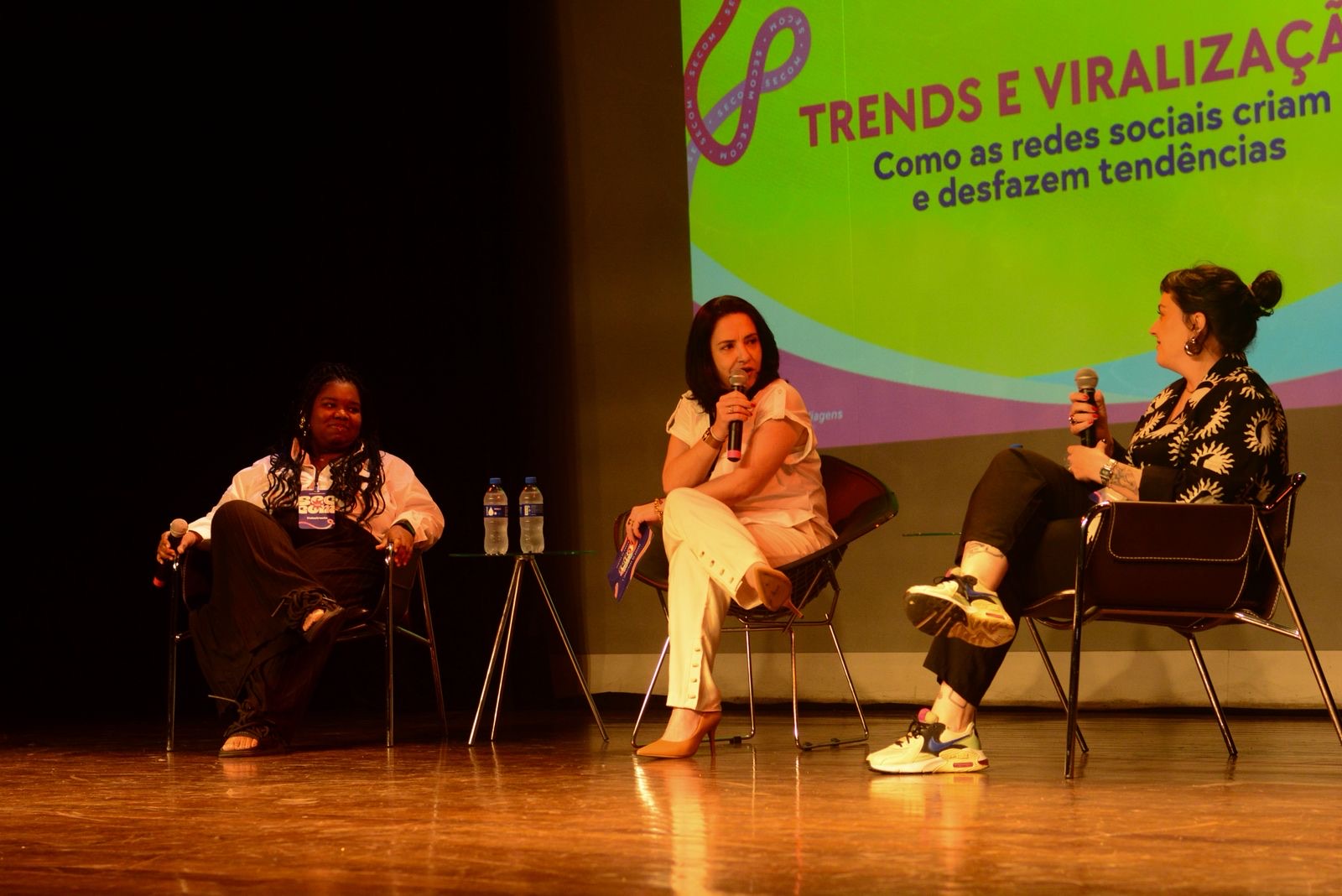 Ketyanne no palco do painel Trends e viralização, com duas painelistas